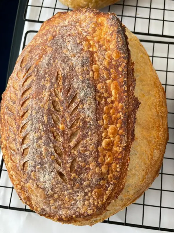 A loaf of bread on top of a cooling rack.