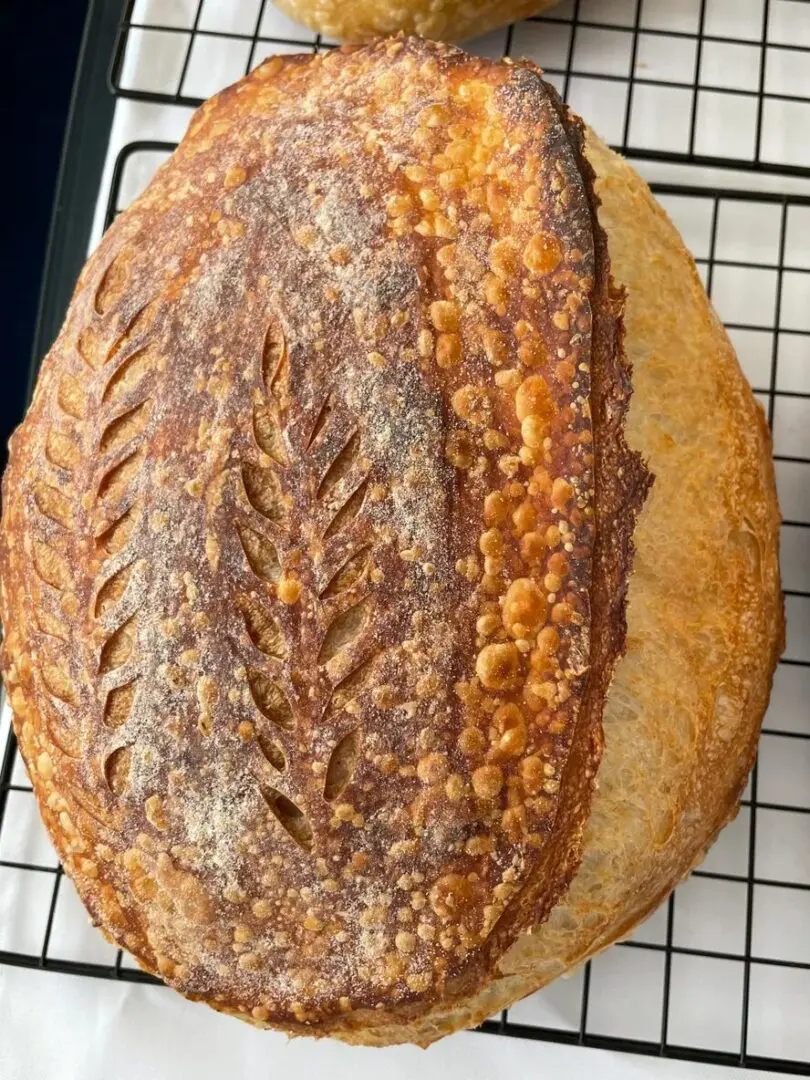 A loaf of bread on top of a cooling rack.