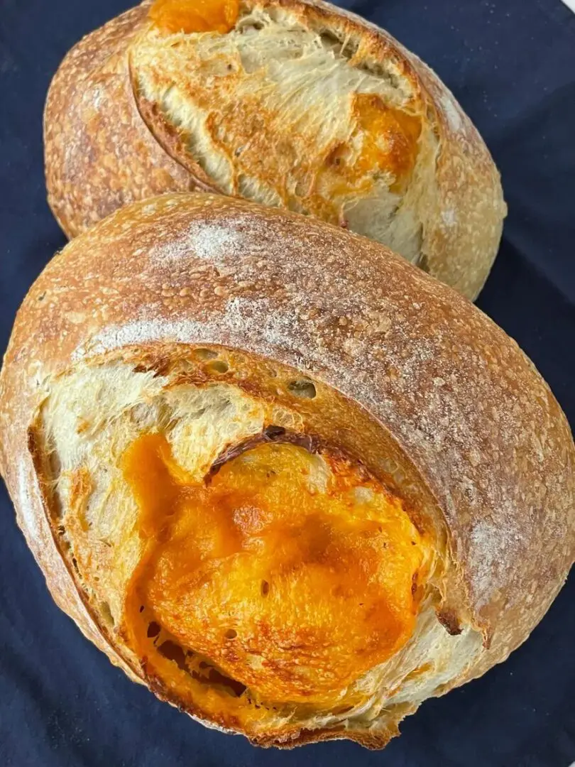 A close up of two bread rolls with cheese