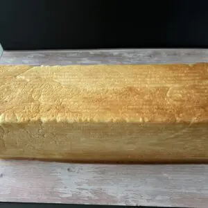 Golden rectangular loaf of soft bread.