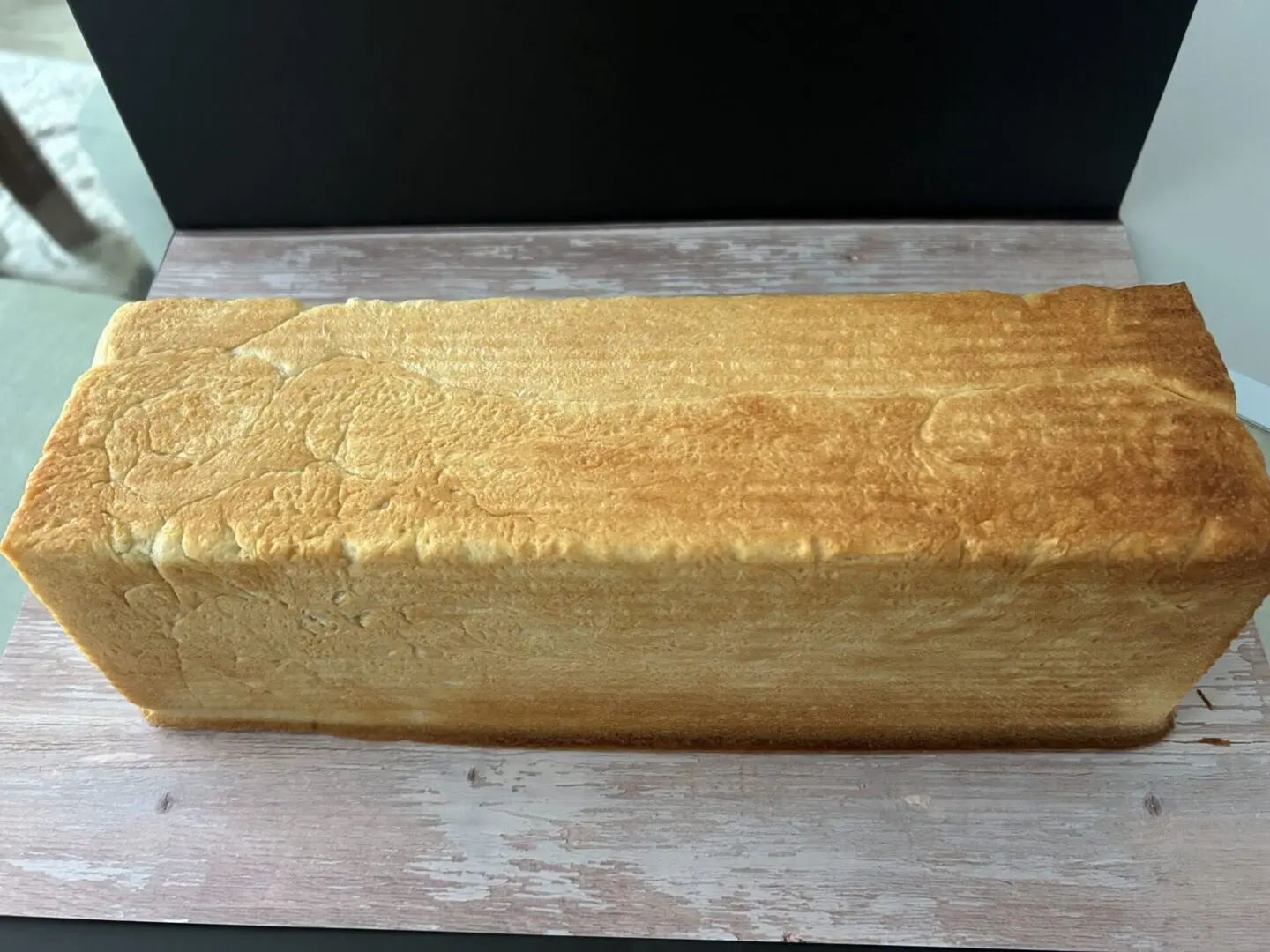 Golden rectangular loaf of soft bread.