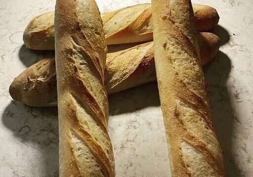 A bunch of bread sitting on top of the counter.